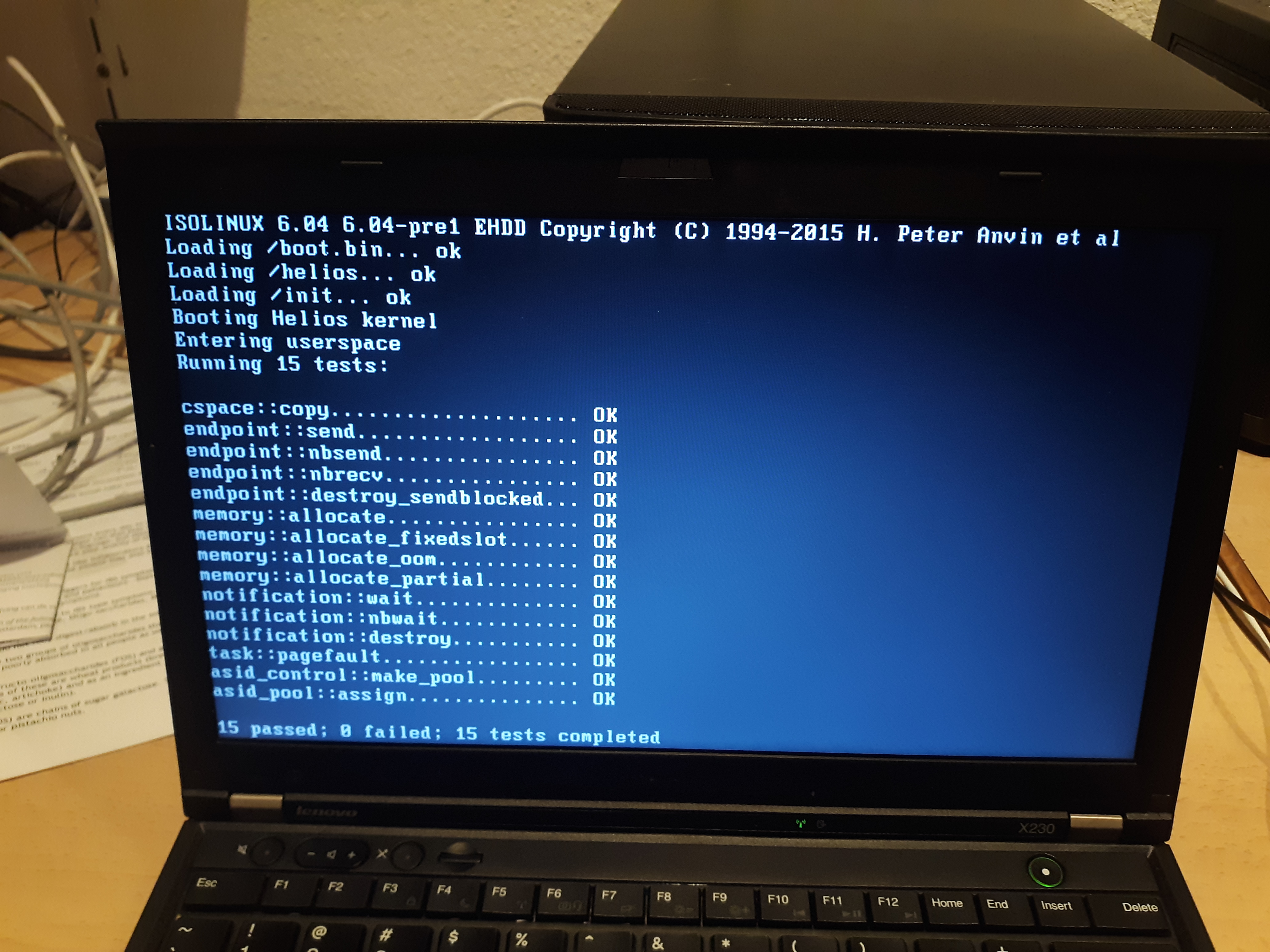 A picture of a laptop showing 15 passing kernel tests